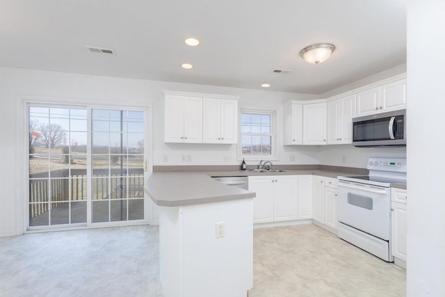 kitchen with white appliances, sink, and white cabinets