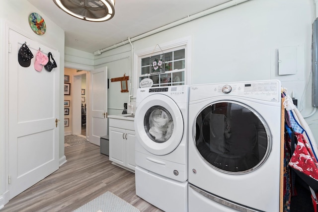 1204 Westmoreland Dr, Staunton, VA 24401 - clothes washing area with washer and clothes dryer, cabinet space, and light wood-style flooring
