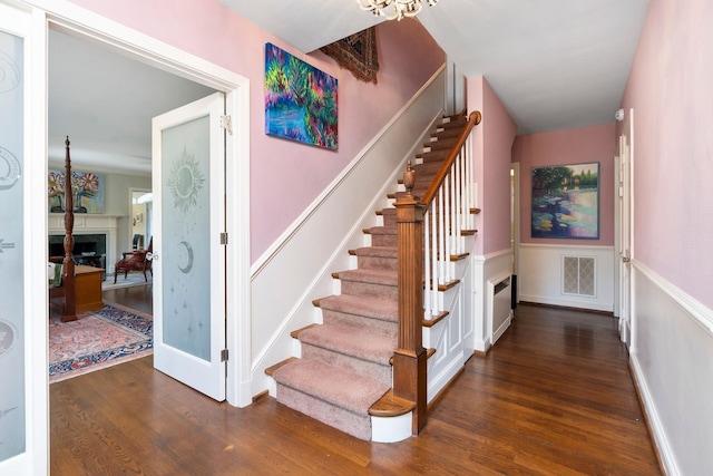 1204 Westmoreland Dr, Staunton, VA 24401 - staircase with a fireplace, wood finished floors, radiator, a chandelier, and baseboards
