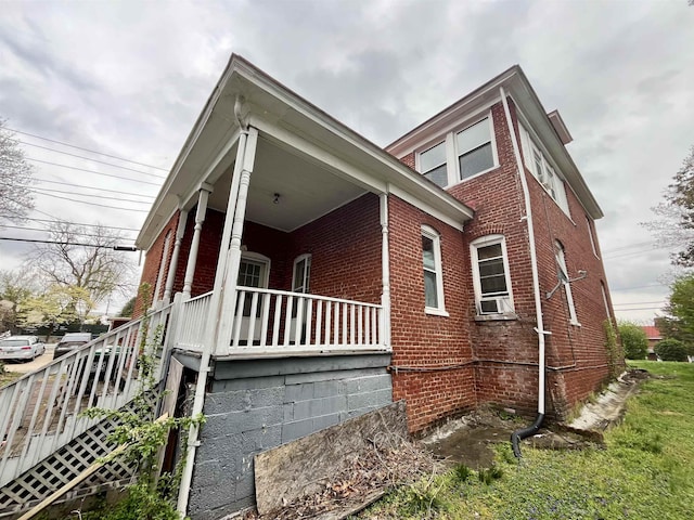 view of home's exterior featuring brick siding and a porch