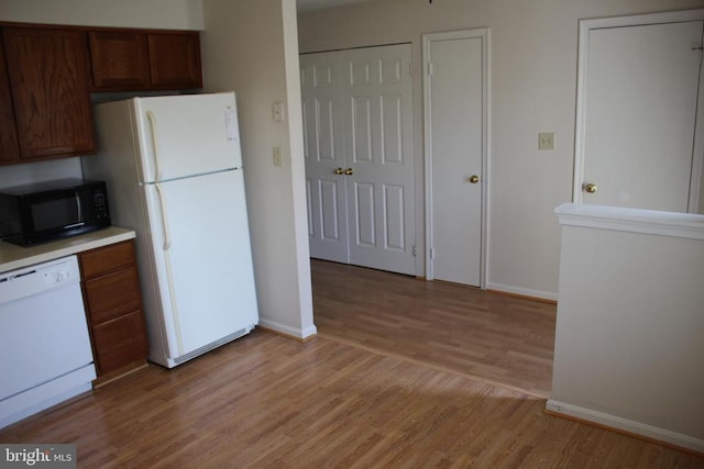 5151 Dominion Dr, Fredericksburg, VA 22407 - kitchen with white appliances, baseboards, light countertops, and light wood-style floors