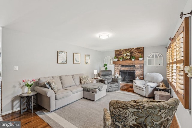  - living area featuring a fireplace, wood finished floors, and a barn door