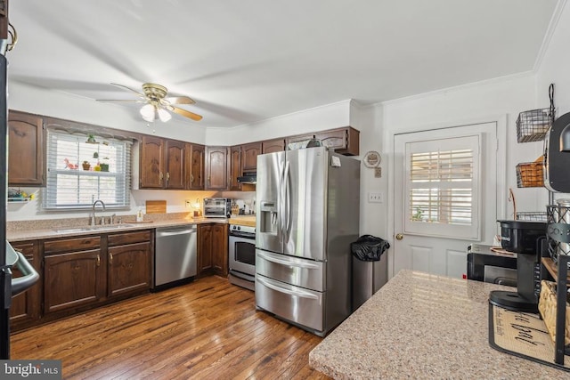  - kitchen featuring stainless steel appliances, a ceiling fan, dark wood-style floors, ornamental molding, and under cabinet range hood