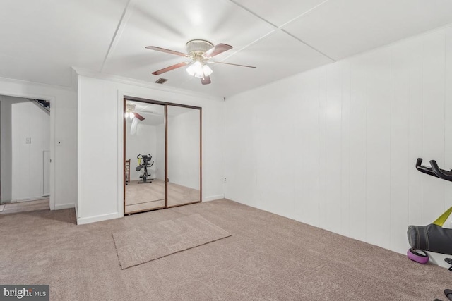  - unfurnished bedroom with carpet, a closet, a ceiling fan, and crown molding