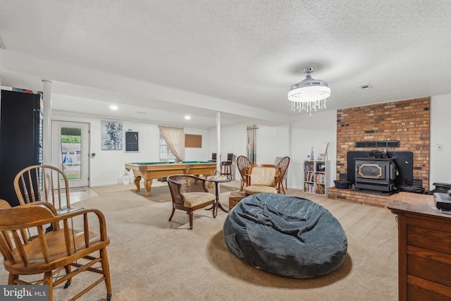  - living area with pool table, a wood stove, light colored carpet, and a textured ceiling