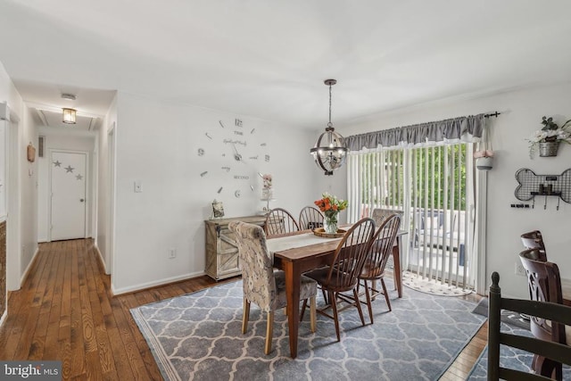  - dining space with hardwood / wood-style flooring and a chandelier