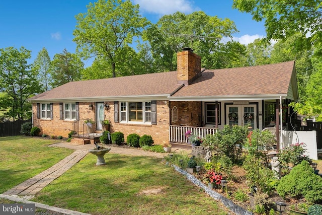  - ranch-style home featuring a chimney, a front yard, brick siding, a shingled roof, and french doors