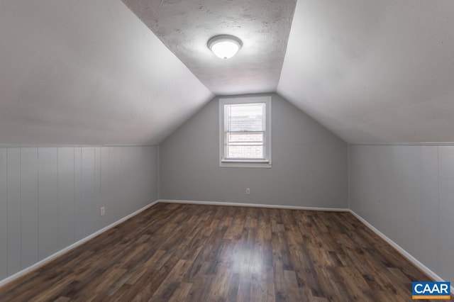 bonus room featuring wood finished floors, vaulted ceiling, and baseboards