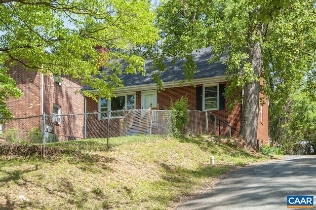 cape cod house featuring brick siding, fence, and a chimney