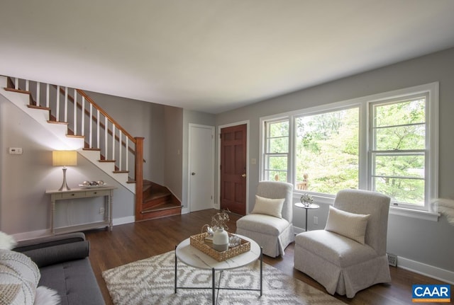 living room featuring stairs, wood finished floors, and baseboards