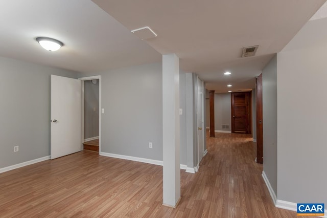 basement with light wood-type flooring and baseboards