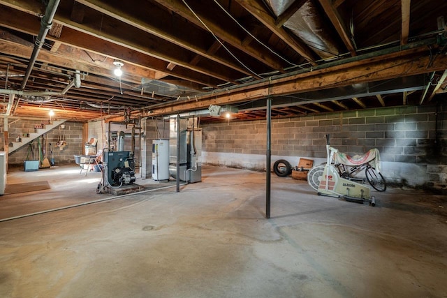 205 Lewis Ave, Elkton, VA 22827 - unfinished below grade area featuring electric water heater, stairs, a heating unit, and heating unit