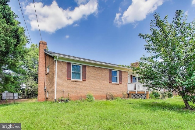 526 Azalea St, Culpeper, VA 22701 - view of side of property featuring a chimney, brick siding, a lawn, a storage shed, and a deck