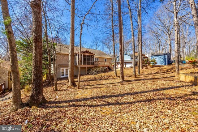 203 Birdie Rd, Locust Grove, VA 22508 - view of front facade featuring a wooden deck, an outdoor structure, a storage unit, french doors, and a sunroom