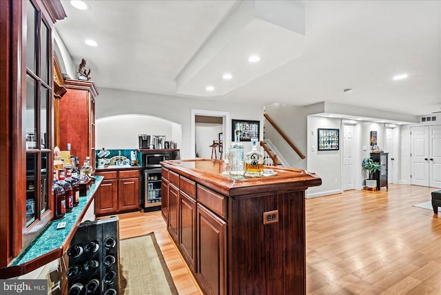 13515 Perimeter Dr, Fredericksburg, VA 22407 - kitchen featuring stainless steel microwave, recessed lighting, light wood-type flooring, wine cooler, and a kitchen island