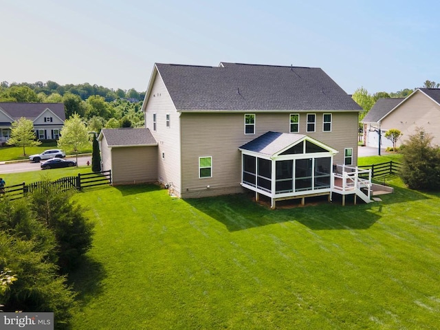  - back of house featuring a sunroom and a shingled roof