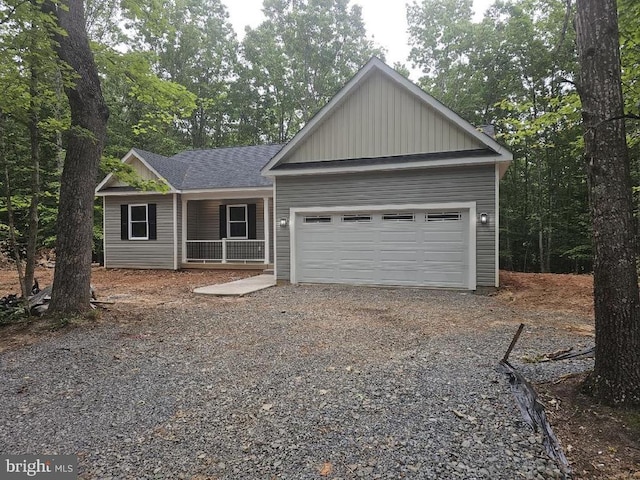 394 Pinehurst Rd, Gordonsville, VA 22942 - view of front facade with gravel driveway, covered porch, an attached garage, board and batten siding, and roof with shingles