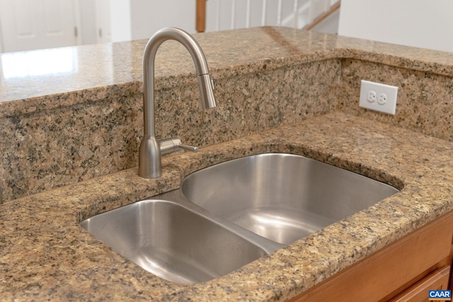 interior details with light stone countertops and a sink