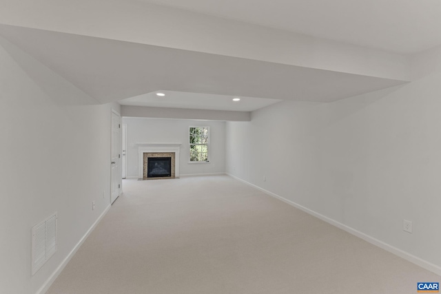 unfurnished living room with light colored carpet, visible vents, a fireplace, and baseboards