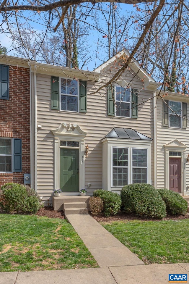 townhome / multi-family property with a front lawn