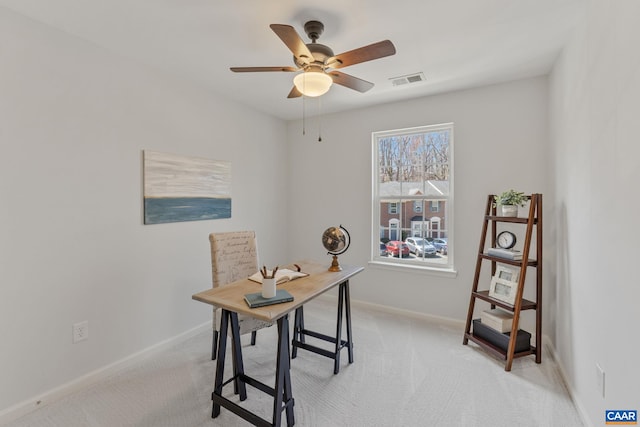 office area featuring baseboards, visible vents, ceiling fan, and light colored carpet