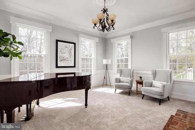  - sitting room featuring carpet, a chandelier, ornamental molding, and wainscoting