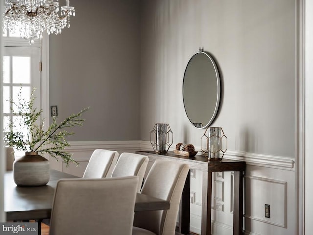  - dining space with a chandelier and wainscoting