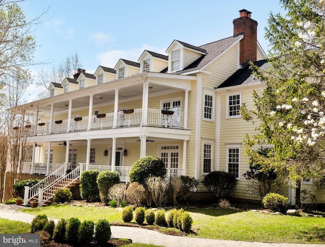  - back of house with a ceiling fan, a balcony, covered porch, and a chimney
