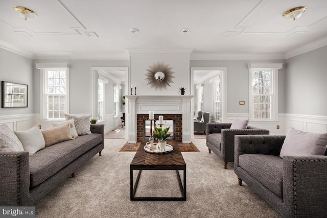  - living room with plenty of natural light, a wainscoted wall, ornamental molding, carpet floors, and a fireplace with flush hearth