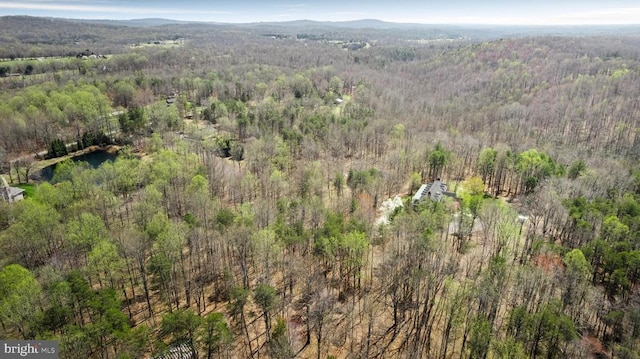  - aerial view of property and surrounding area with a forest and a mountainous background