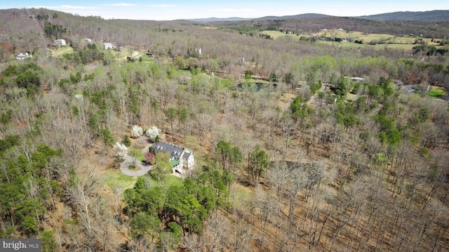  - bird's eye view of a heavily wooded area and a mountainous background