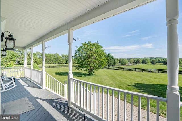  - wooden porch featuring a view of rural / pastoral area and view of scattered trees