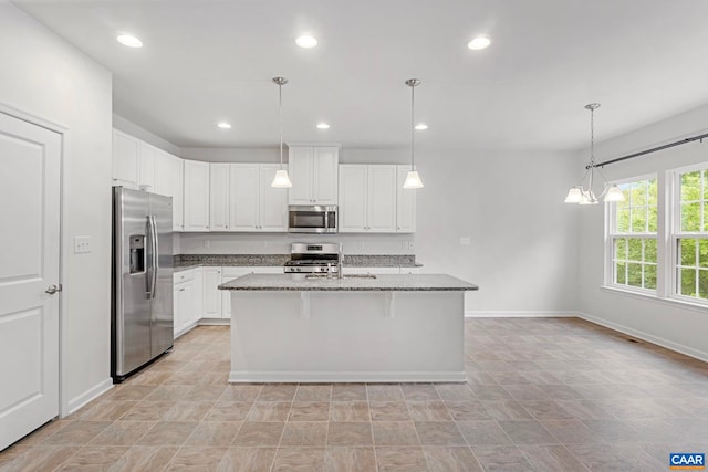 281 Manor Blvd, Palmyra, VA 22963 - kitchen with appliances with stainless steel finishes, dark stone counters, baseboards, white cabinetry, and an island with sink