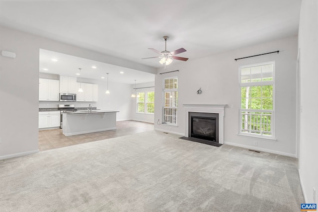 281 Manor Blvd, Palmyra, VA 22963 - unfurnished living room featuring baseboards, light carpet, ceiling fan, recessed lighting, and a sink