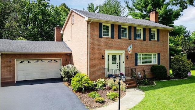 935 Glenwood Blvd, Waynesboro, VA 22980 - colonial house with a chimney, driveway, a front yard, an attached garage, and brick siding