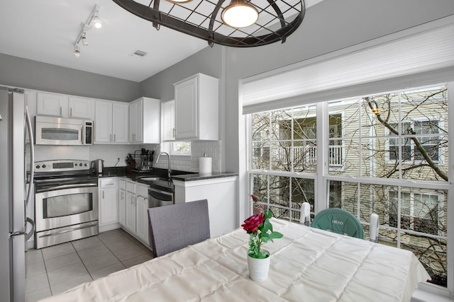 4551 Strutfield Ln Unit 4337, Alexandria, VA 22311 - kitchen featuring a sink, visible vents, white cabinetry, light tile patterned floors, and appliances with stainless steel finishes