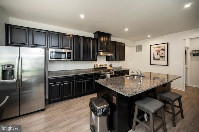 9323 Wood Creek Cir, Fredericksburg, VA 22407 - kitchen featuring appliances with stainless steel finishes, a sink, dark cabinetry, a breakfast bar, and recessed lighting