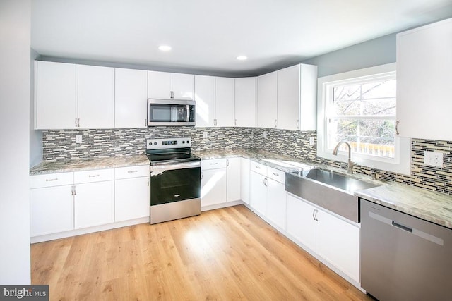 19196 Ferguson Ln, Jeffersonton, VA 22724 - kitchen featuring a sink, white cabinetry, appliances with stainless steel finishes, decorative backsplash, and light stone counters