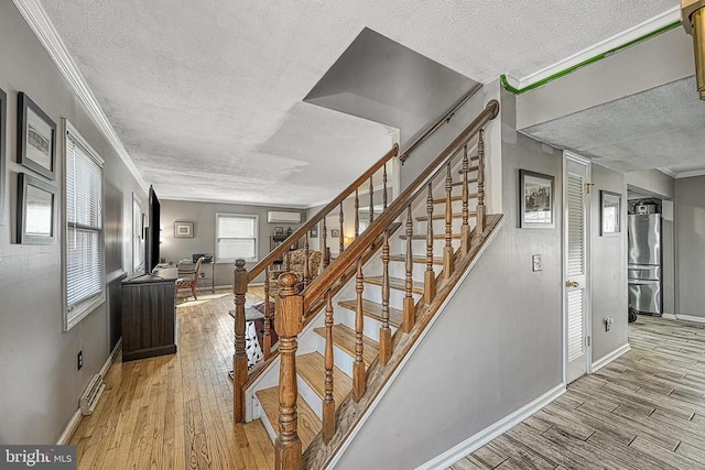 119 Birchside Cir, Locust Grove, VA 22508 - stairs with a textured ceiling, a wall unit AC, wood finished floors, baseboards, and ornamental molding
