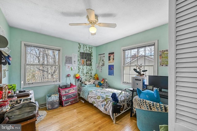 119 Birchside Cir, Locust Grove, VA 22508 - bedroom with multiple windows, hardwood / wood-style floors, a textured ceiling, and a ceiling fan