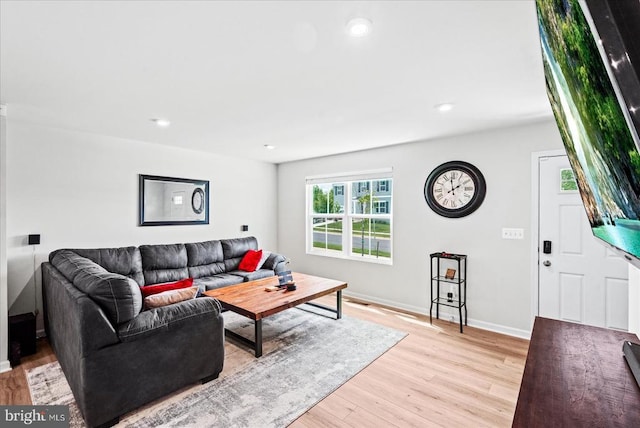 living room featuring light wood-style flooring, baseboards, and recessed lighting