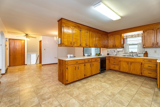 4490 N Valley Pike, Rockingham, VA 22802 - kitchen featuring brown cabinets, dishwasher, light countertops, a ceiling fan, and arched walkways