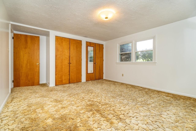 4490 N Valley Pike, Rockingham, VA 22802 - unfurnished bedroom featuring two closets, a textured ceiling, and carpet flooring