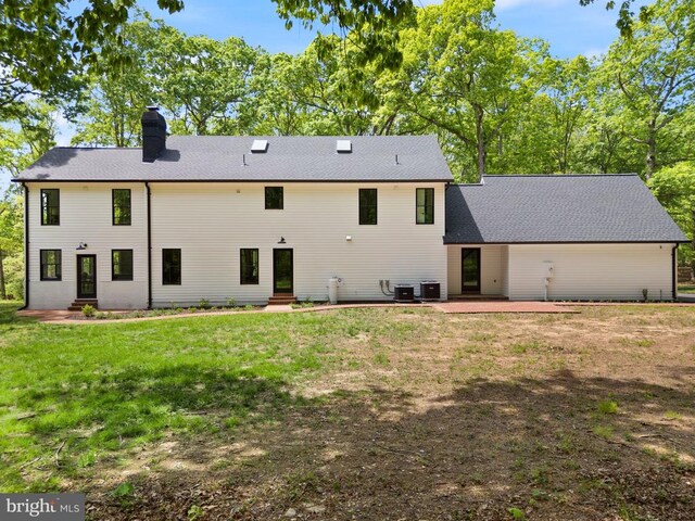  - rear view of house featuring a patio area, a yard, entry steps, cooling unit, and a chimney