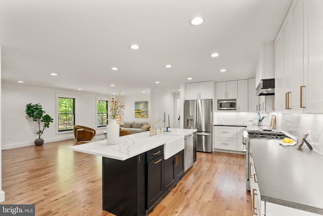  - kitchen with open floor plan, white cabinetry, under cabinet range hood, appliances with stainless steel finishes, and recessed lighting