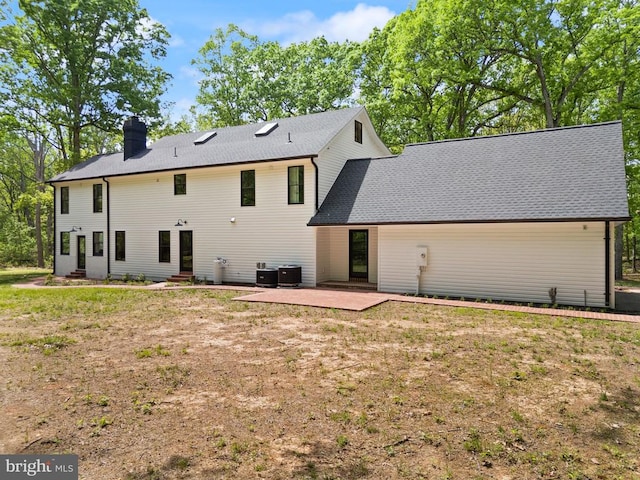  - back of house featuring central AC unit, a patio, a yard, and a chimney