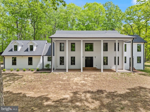  - view of front facade featuring a patio area and a shingled roof