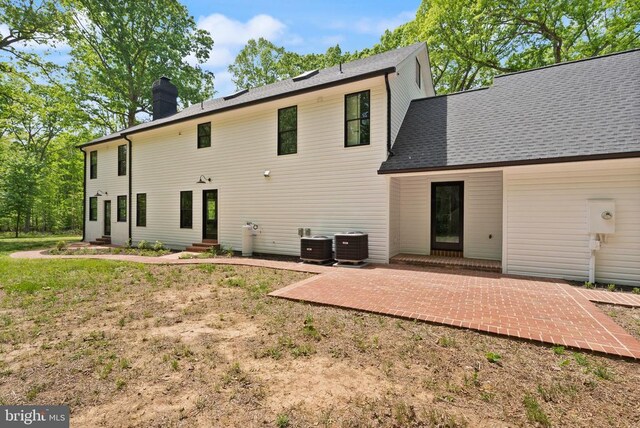  - back of house with a chimney, a patio area, a shingled roof, central AC unit, and entry steps