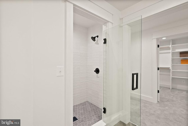  - bathroom with a stall shower, a walk in closet, and baseboards