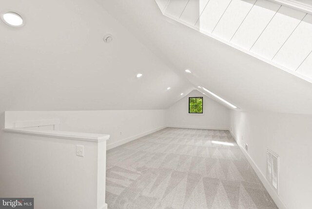  - additional living space with visible vents, recessed lighting, vaulted ceiling, light carpet, and baseboards